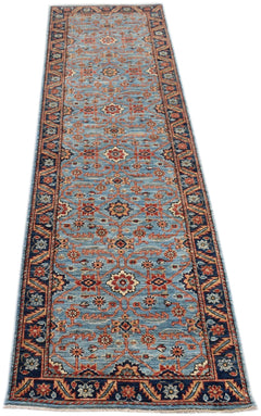 A handmade Afghan Chobi runner rug featuring a traditional floral pattern in blue and rust tones.