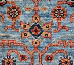 A handmade Afghan Chobi runner featuring a traditional floral pattern in red, blue, and tan.