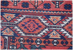 A close-up of a handwoven Afghan Chobi runner featuring traditional geometric patterns in red and blue.
