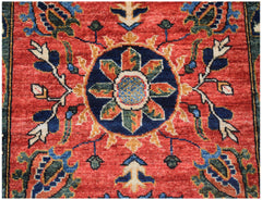 An Afghan Chobi runner featuring a central floral medallion on a red field with blue accents.