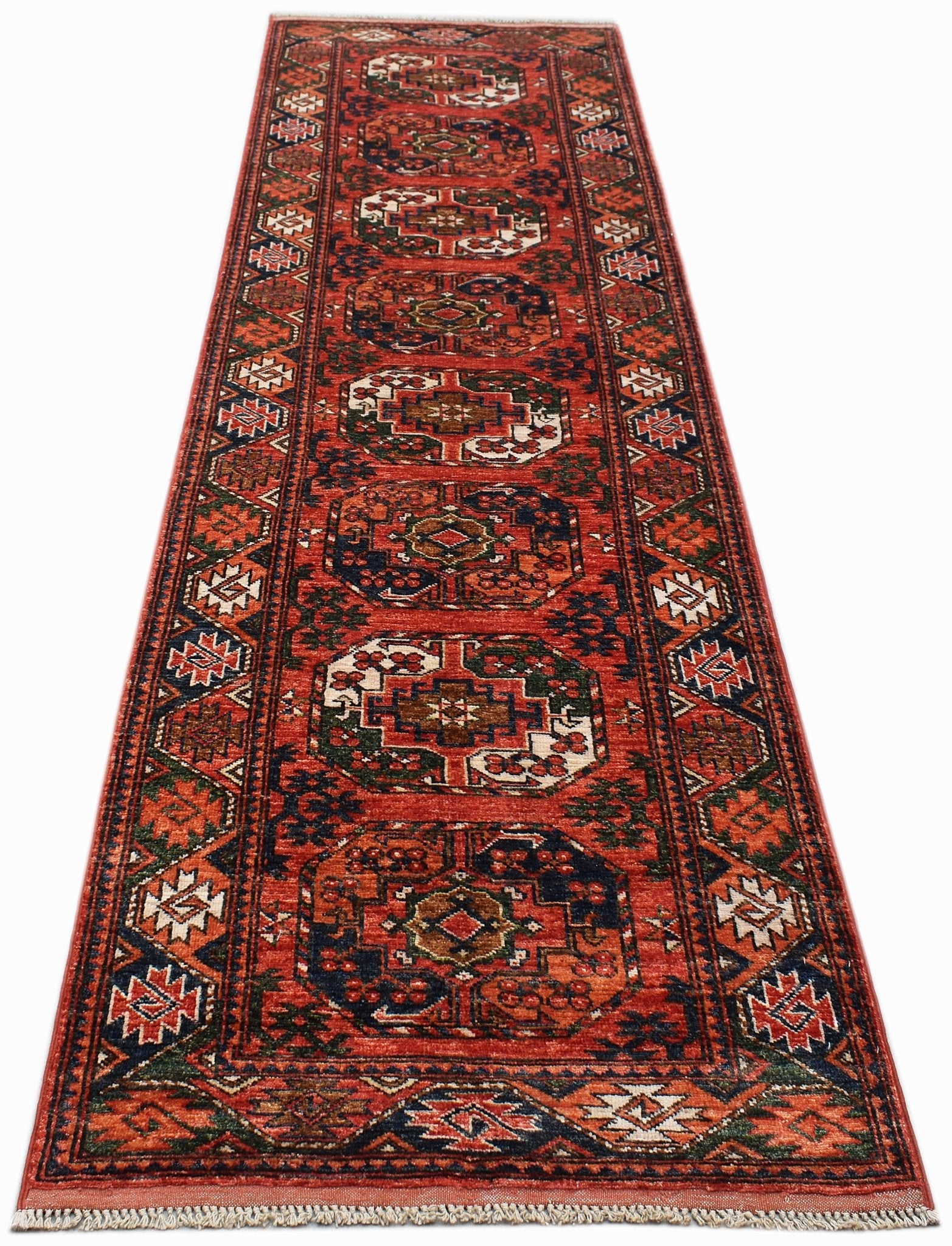 A handmade Afghan Chobi runner rug featuring traditional geometric patterns in red and blue tones.