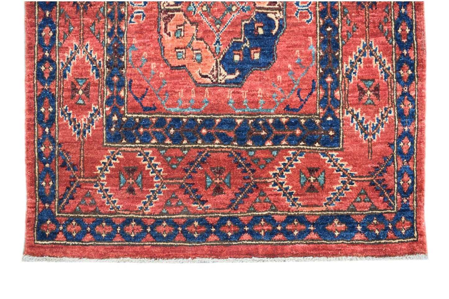 A handmade Afghan Chobi runner featuring a traditional red field with blue geometric patterns.