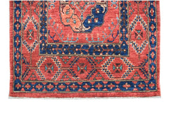 A handmade Afghan Chobi runner featuring a traditional red field with blue geometric patterns.