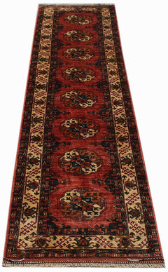 A handmade Afghan Chobi runner rug featuring a repeating geometric medallion pattern in red wool.