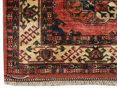 A corner view of a handwoven Afghan Chobi runner featuring traditional geometric patterns in red and cream.