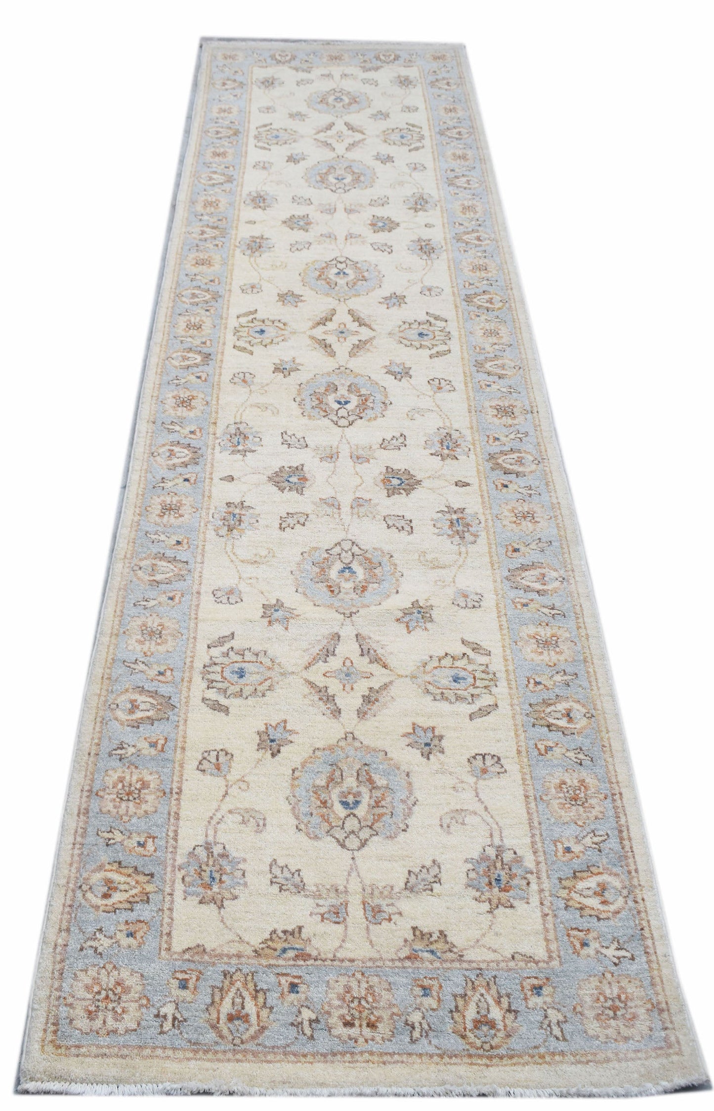 An Afghan Chobi runner rug featuring a traditional floral pattern in soft blue and beige tones.