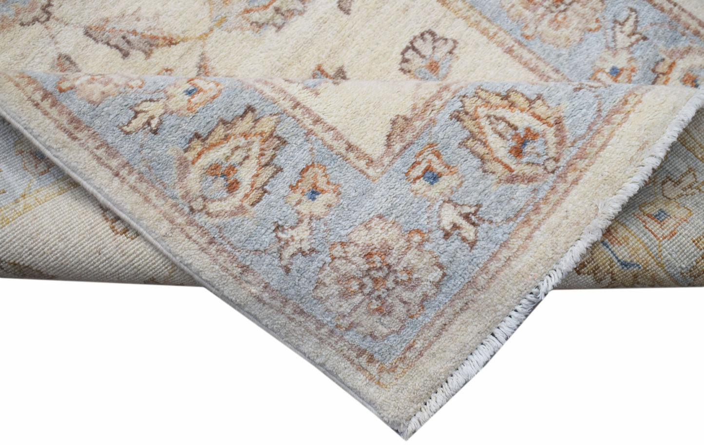 A corner view of a handwoven Afghan Chobi runner featuring traditional floral patterns in soft tones.