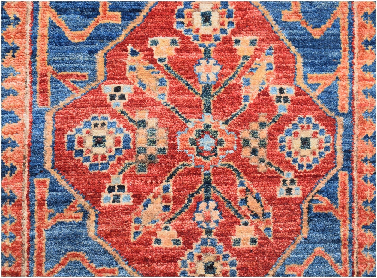 An Afghan Chobi runner featuring a traditional red diamond medallion pattern on a blue background.