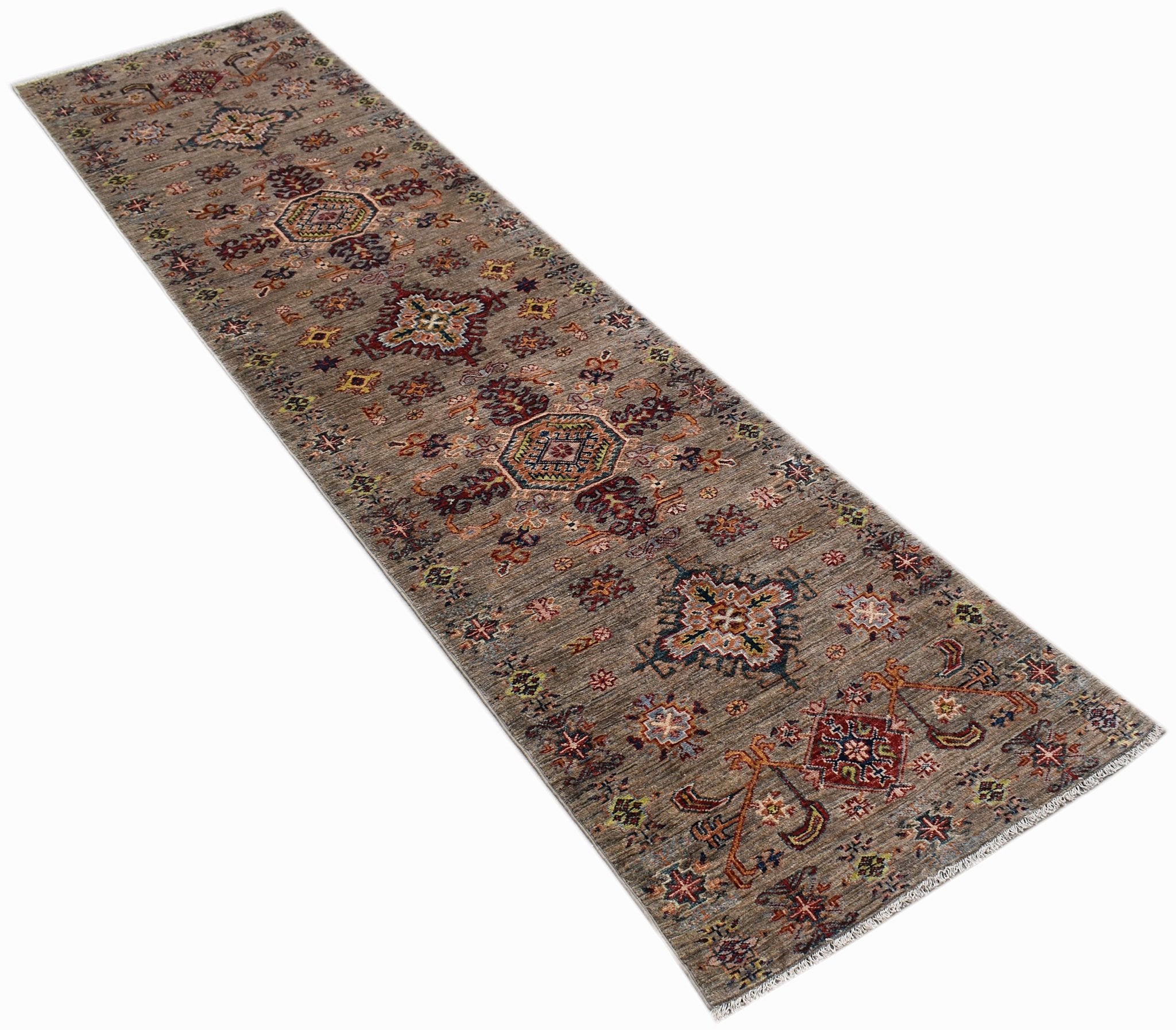 A handmade Afghan Chobi runner rug featuring traditional geometric patterns in earthy wood tones.
