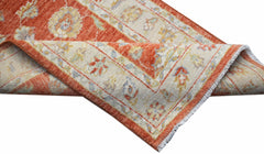 A handmade Afghan Chobi runner featuring a traditional floral pattern in orange and cream tones.