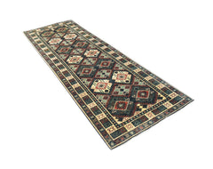 A handmade Afghan Chobi runner rug featuring a traditional geometric pattern in earthy tones.