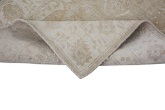 A corner of a handmade Afghan Chobi runner with a neutral, wood-toned traditional pattern.
