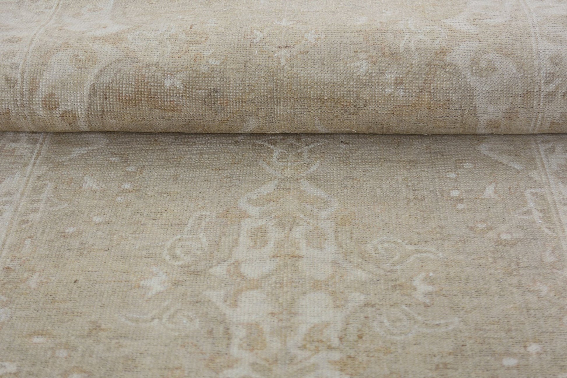 A close-up of a handmade Afghan Chobi runner featuring a subtle, light beige floral pattern.