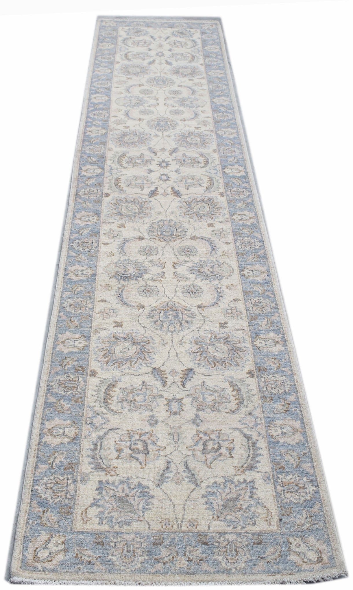 A handmade Afghan Chobi runner rug featuring a traditional floral pattern in blue and cream tones.
