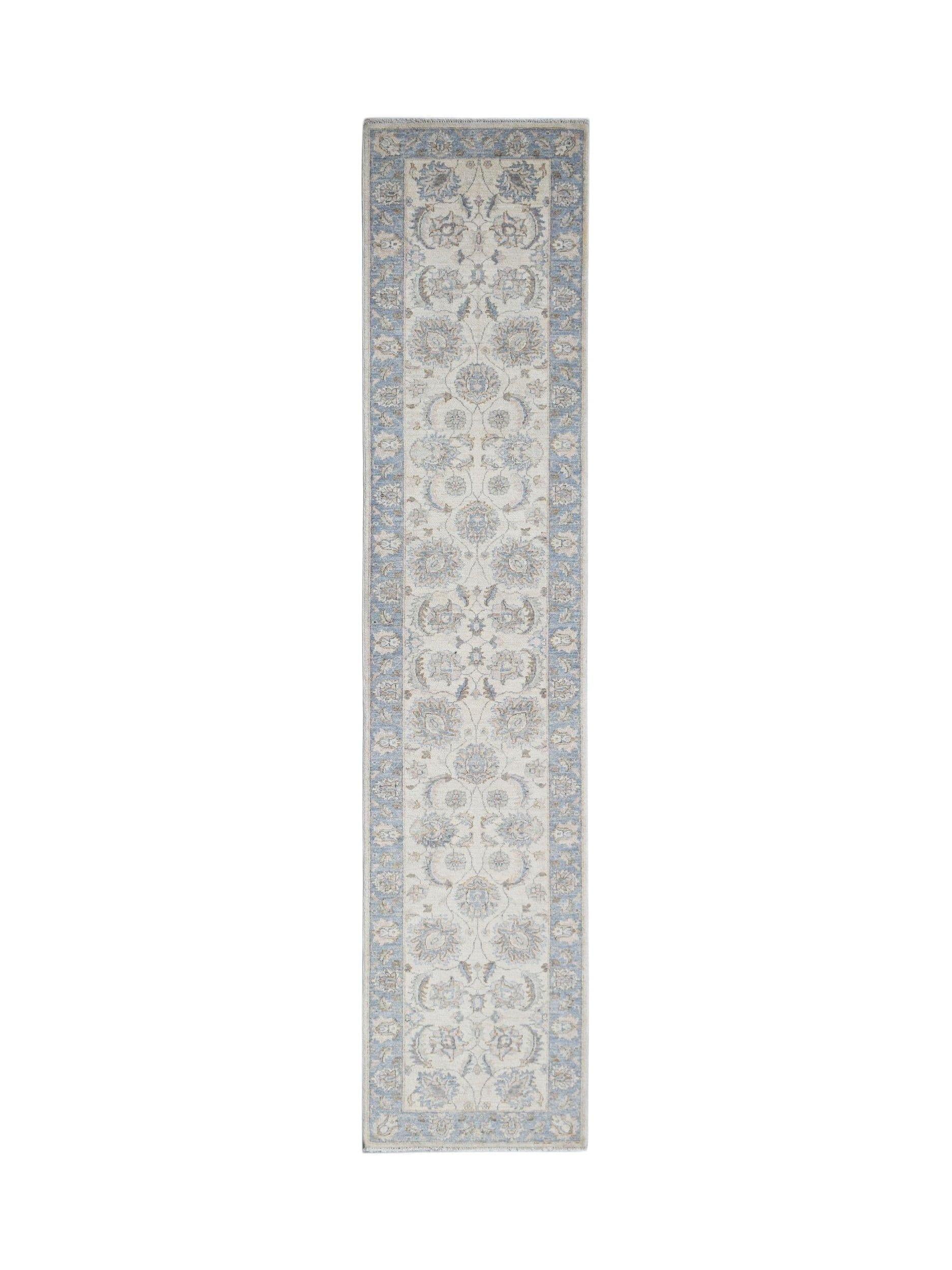 A handmade Afghan Chobi runner rug featuring a traditional floral pattern in blue and cream tones.