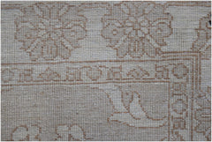 A close-up of an Afghan Chobi runner featuring intricate, light brown floral patterns on wool.