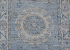 A handmade Afghan Chobi runner rug featuring a central floral medallion in blue and beige tones.