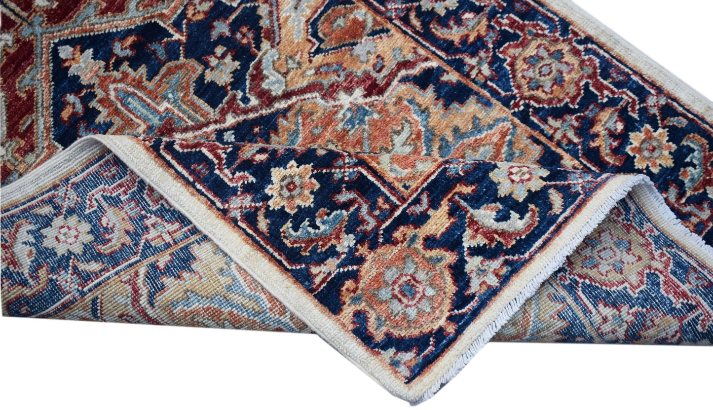 A handwoven Afghan Chobi runner featuring a traditional floral pattern in blue, red, and tan.