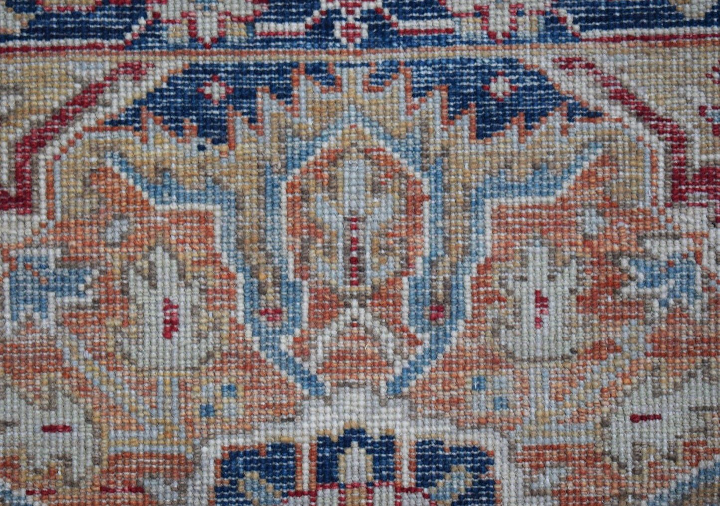 A close-up of a handwoven Afghan Chobi runner featuring intricate floral patterns in earthy tones.