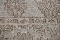 A close-up of a handwoven Afghan Chobi runner featuring traditional floral patterns in beige tones.