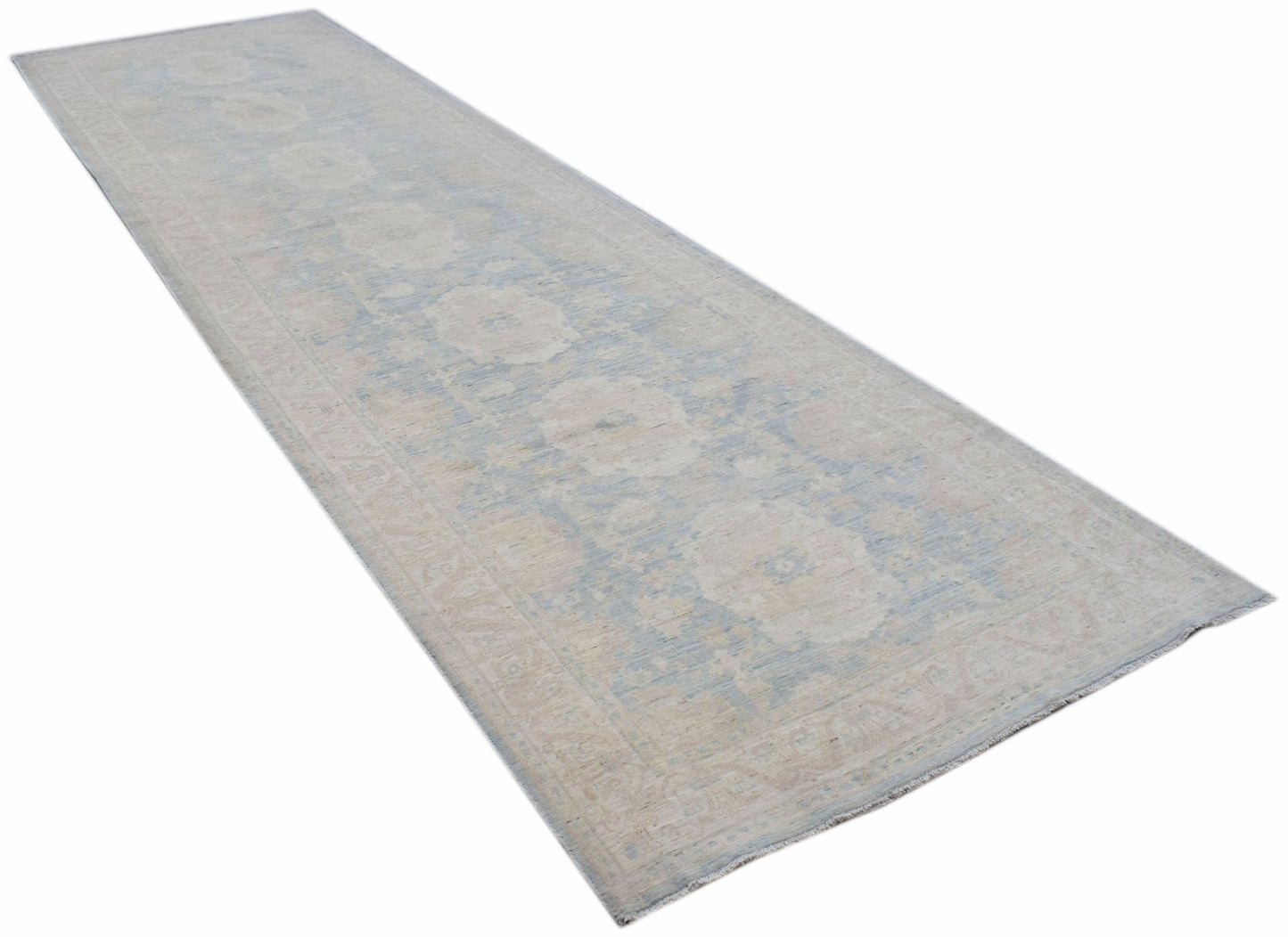 A long, handwoven Afghan Chobi runner rug featuring a traditional floral pattern in soft blue tones.