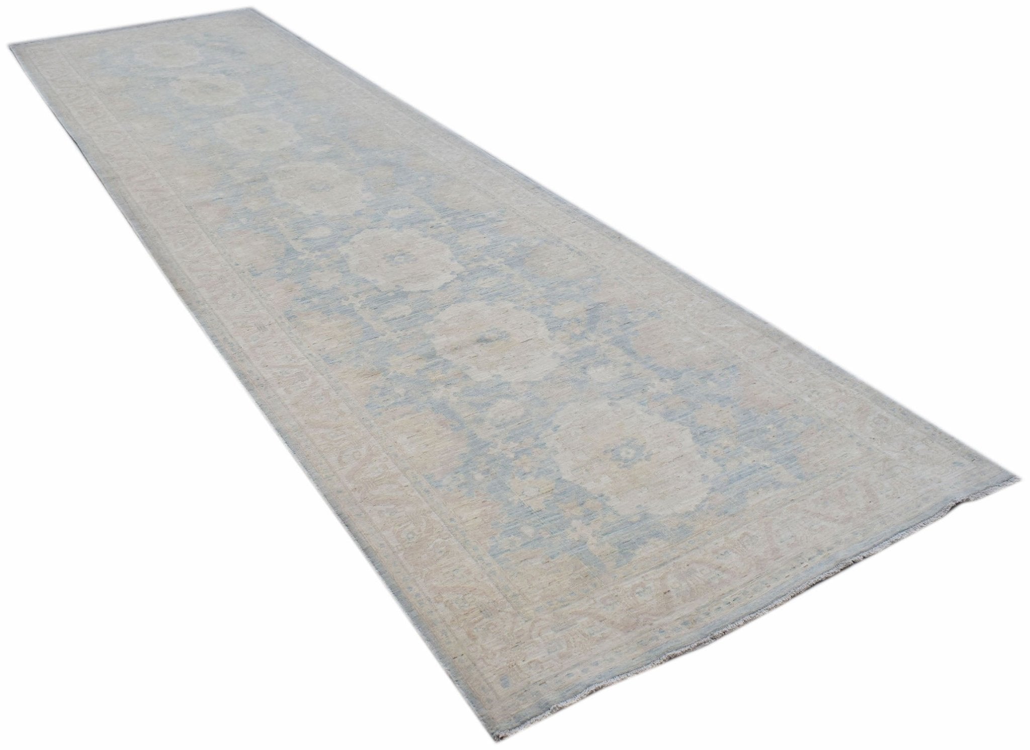 A long, handwoven Afghan Chobi runner rug featuring a traditional floral pattern in soft blue tones.