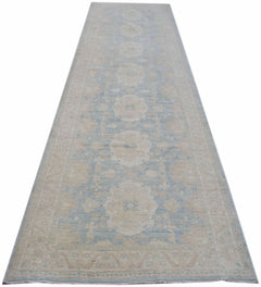 A long, handmade Afghan Chobi runner rug featuring a light blue and beige floral pattern.