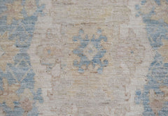 A close-up of an Afghan Chobi runner featuring a traditional floral pattern in blue and beige.
