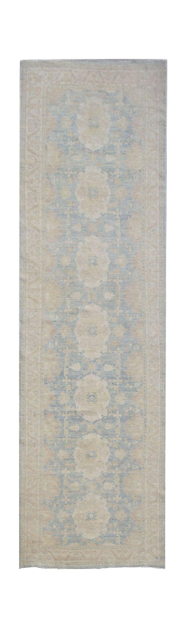 Handwoven Afghan Chobi runner rug featuring a traditional floral pattern in blue and beige tones.