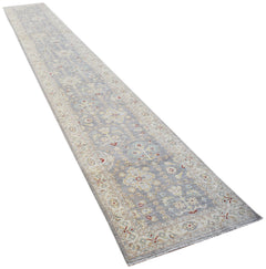 A long, handmade Afghan Chobi runner rug featuring a traditional floral pattern in soft grey tones.