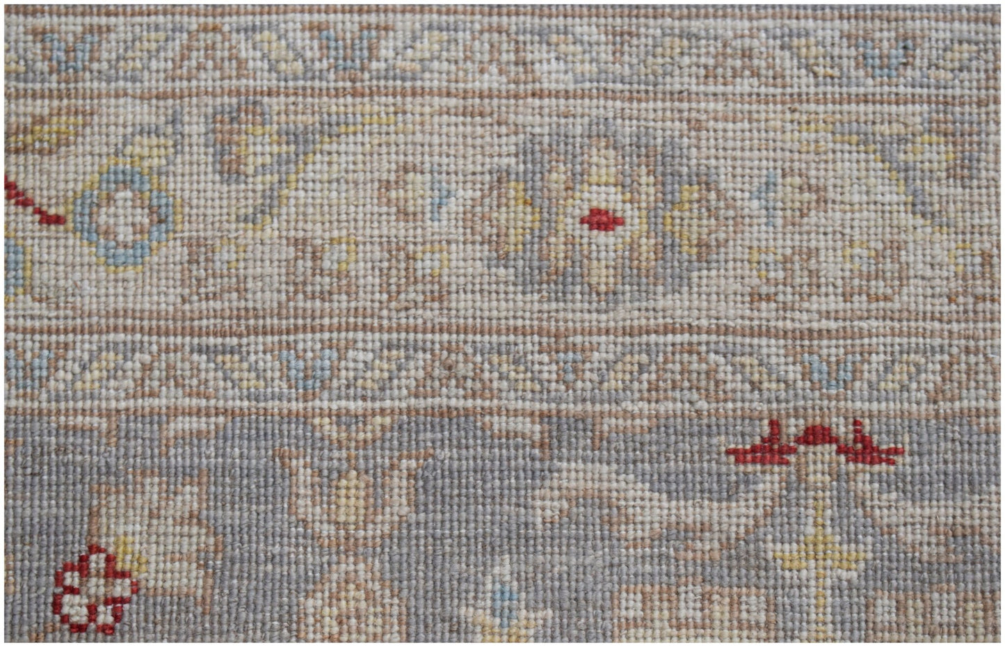 A close-up of an Afghan Chobi runner featuring intricate floral patterns in muted earth tones.