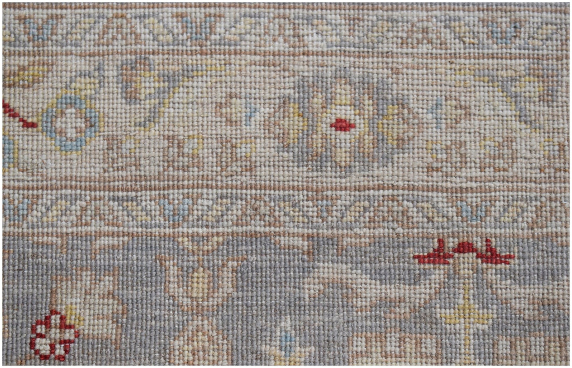 A close-up of an Afghan Chobi runner featuring intricate floral patterns in muted earth tones.