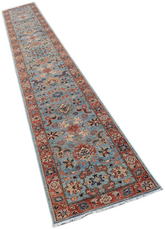 A long, handmade Afghan Chobi runner rug featuring a traditional floral pattern in blue and red.