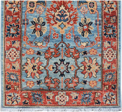 Handmade Afghan Chobi runner rug featuring a traditional floral pattern in blue and red tones.