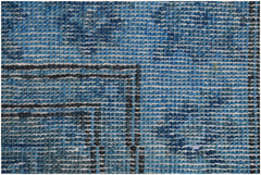 A close-up view of a handmade Afghan Chobi runner featuring a textured blue overdyed wool pattern.