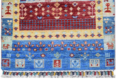 A handmade Afghan Chobi runner featuring a vibrant geometric and floral pattern in blue, red, and yellow.