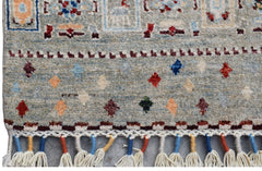 A handmade Afghan Chobi runner featuring a light blue field with colorful geometric motifs.