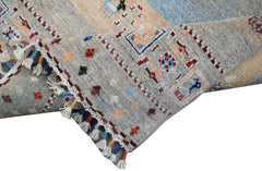 A handmade Afghan Chobi runner featuring a light blue and beige pattern with decorative tassels.