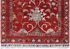 A handmade Afghan Chobi runner rug featuring a floral Suzani pattern on a deep red background.