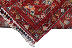 A handmade Afghan Chobi runner featuring a traditional red floral pattern and tasseled edges.
