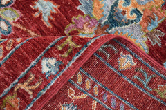A close-up of a handmade Afghan Chobi runner featuring a traditional red floral pattern.