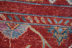 A close-up of a handmade Afghan Chobi runner featuring intricate floral patterns in red and blue.