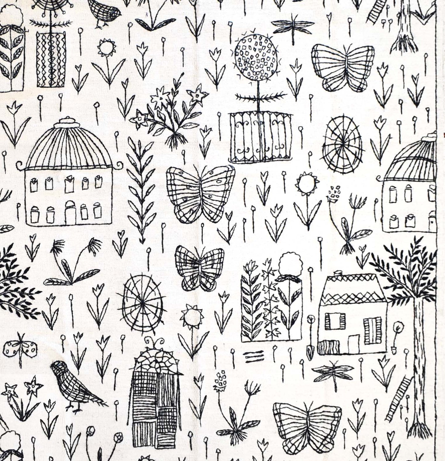 A white wool kilim featuring a black hand-embroidered pattern of houses, butterflies, and flowers.