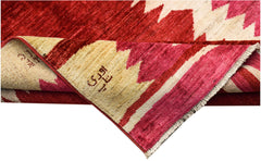 A handmade Afghan Gabbeh rug featuring a geometric pattern in shades of red and cream.