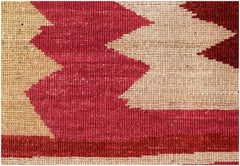 A close-up of a handmade Afghan Gabbeh rug featuring bold geometric patterns in red and cream wool.
