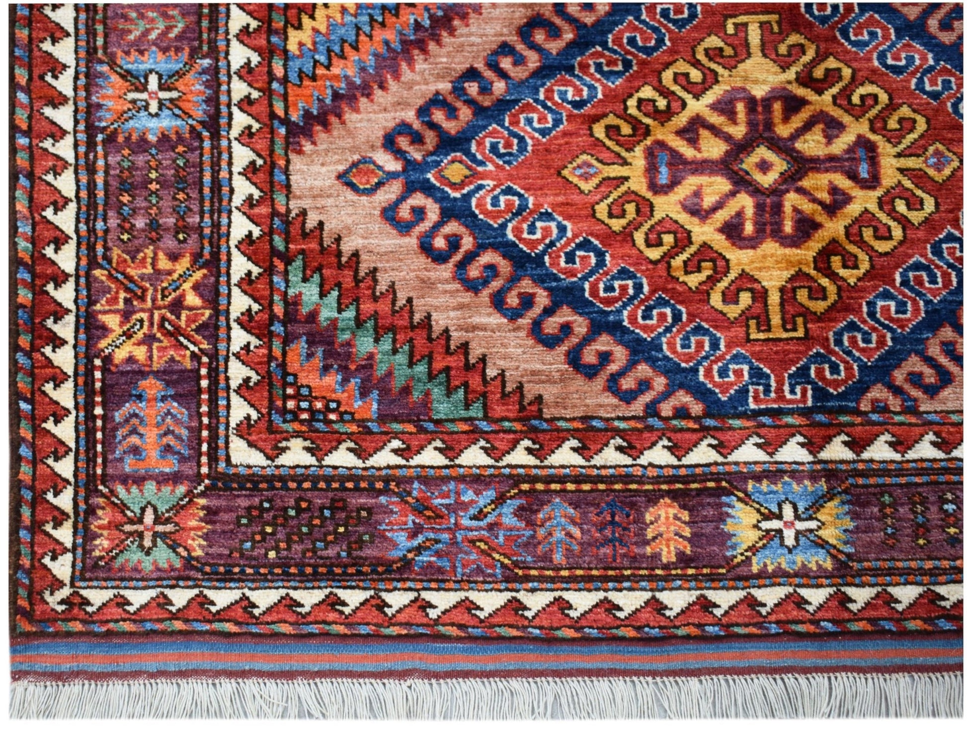 A handmade Afghan Herati rug featuring intricate geometric patterns in red, blue, and purple wool.