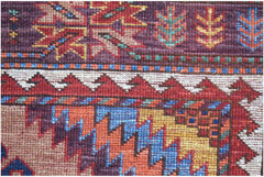 A close-up of a handwoven Afghan Herati rug featuring intricate geometric patterns in wool.