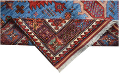 A handwoven Afghan Herati rug featuring intricate geometric patterns in blue, red, and purple.