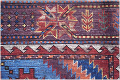 A close-up of a handwoven Afghan Herati rug featuring intricate geometric patterns in wool.
