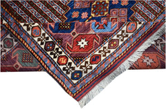 A folded Afghan Herati rug featuring intricate geometric patterns in blue, red, and cream wool.
